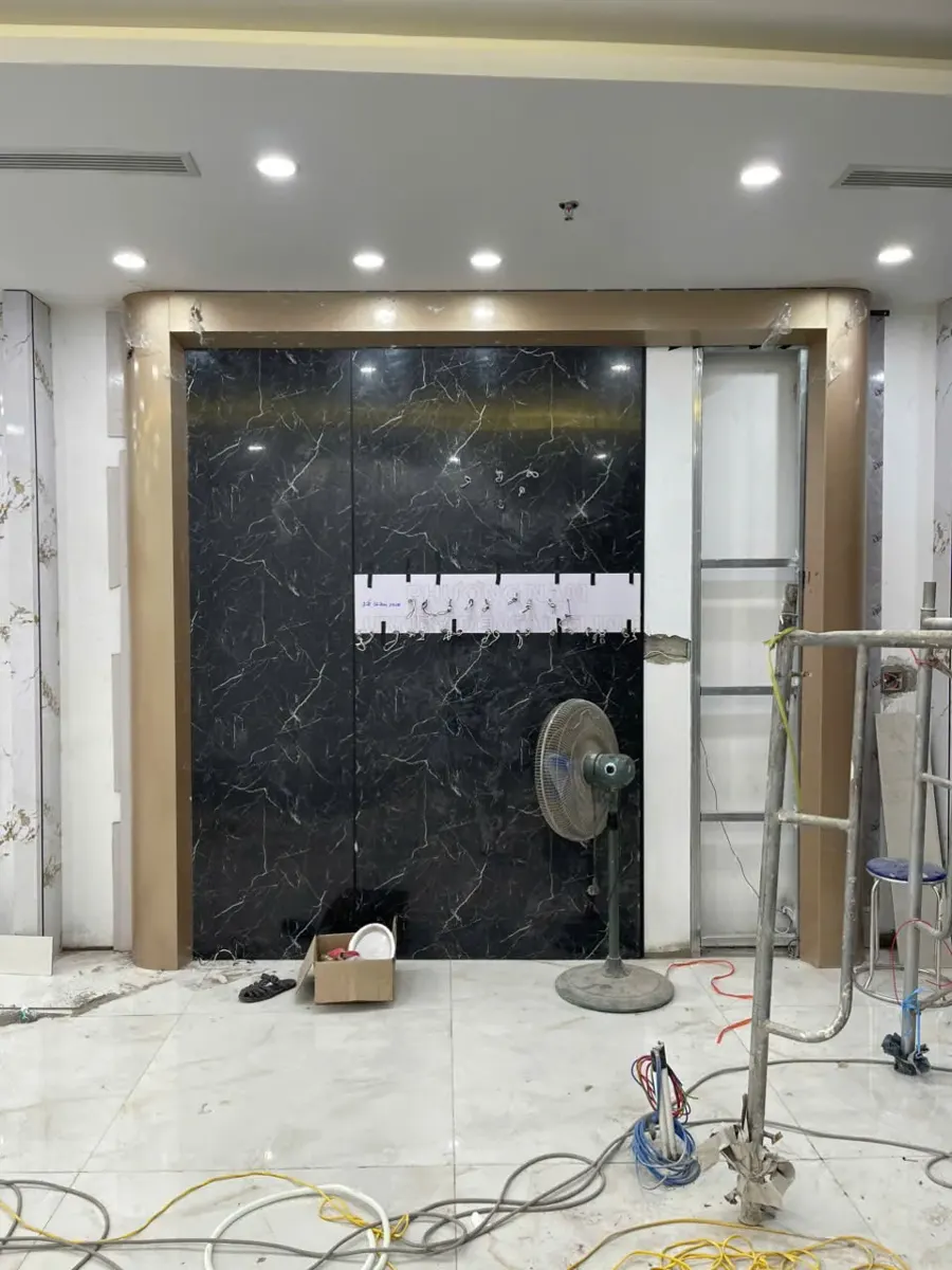 Vách tấm ốp vân đá đen viền khung màu đồng